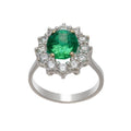 Bague marguerite en or blanc 18 carats, émeraude ovale vert intense environ 1,90 carat en serti 4 griffes or jaune, halo de 12 diamants ronds brillants serti 4 griffes individuelles, anneau poli fin, vue de face