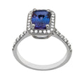 Bague halo en or blanc 18 carats, tanzanite taille coussin bleu-violet environ 1,50 carat en serti 4 griffes, halo carré de diamants ronds serti grain, épaulements pavés de diamants sur anneau effilé, vue de face