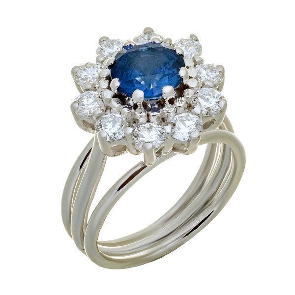 Bague entourage en or blanc 18 carats, saphir rond bleu intense environ 1,55 carat en serti griffes, halo de 10 diamants ronds brillants serti griffes, corps triple anneau fil poli, vue de côté