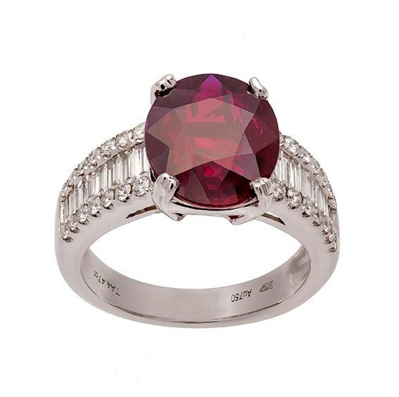 Bague en or blanc 18 carats, rubis ovale rouge intense environ 3,50 carats en serti 4 griffes doubles, épaulements composés d’un rang central de diamants baguettes flanqué de deux rangs de diamants ronds serti grain, vue de face