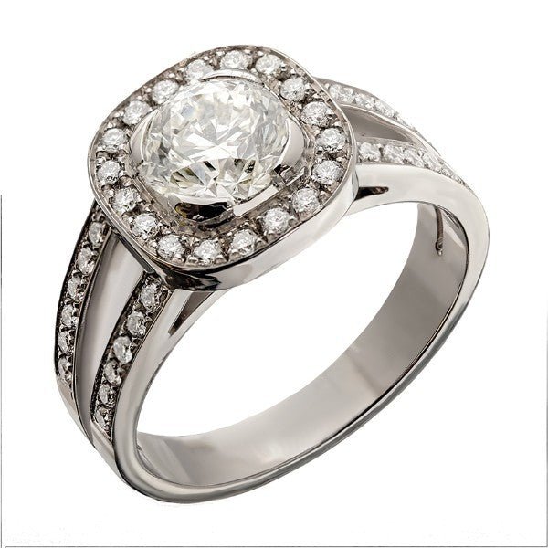 Bague solitaire en or blanc 18 carats, diamant central rond environ 1,05 carat en serti mi-lunette, halo de diamants ronds sur cadre coussin, double anneau fendu pavé sur épaulements évidés, vue de côté