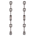 Paire de boucles d'oreilles pendantes en or blanc 18 carats, ligne verticale de 5 diamants multitailles : 3 diamants ronds serti lunette demi-clos, 1 diamant baguette serti rail, 1 diamant poire serti lunette en pendant final, vue de face